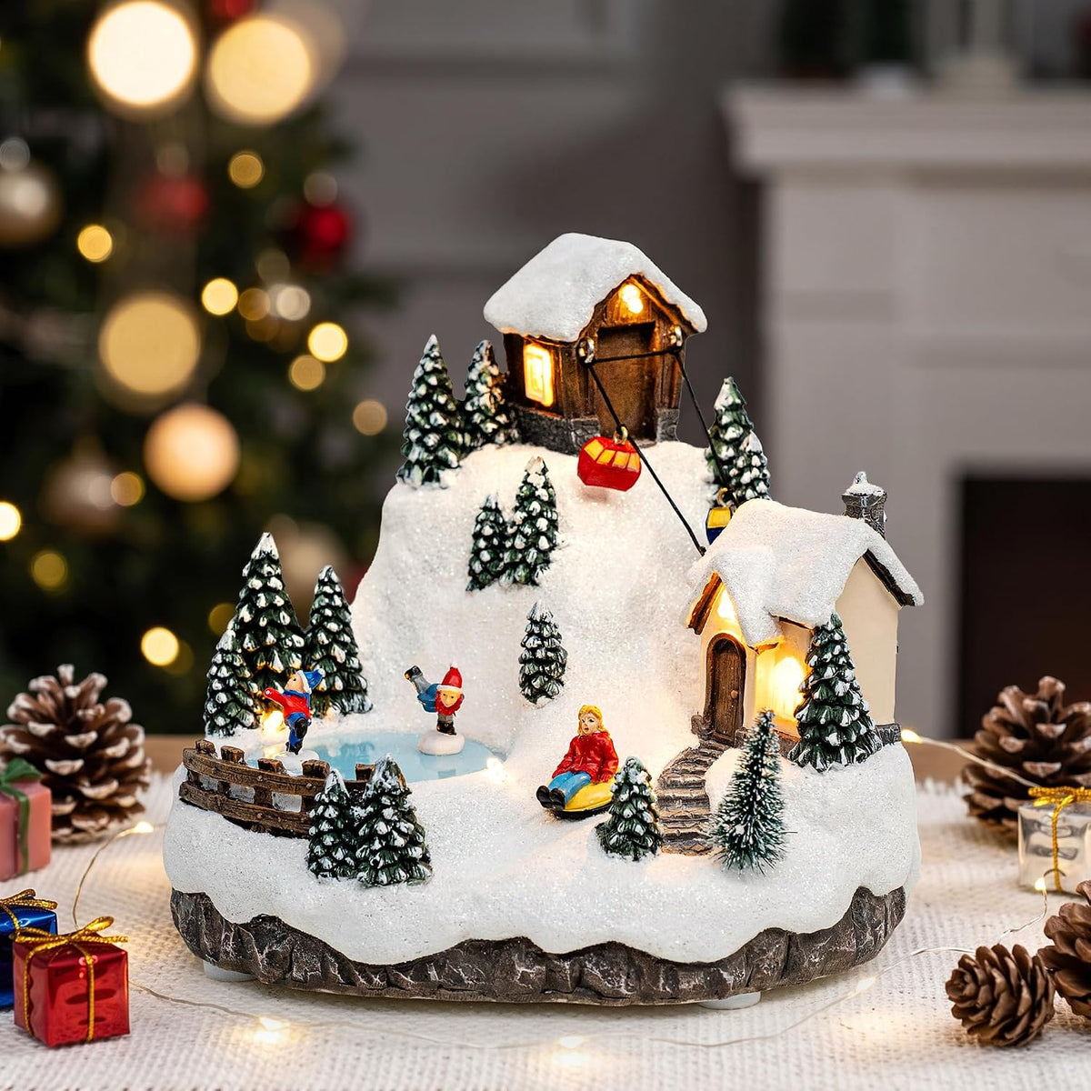 Montaña musical de pueblo navideño con teleférico y patinadores sob...